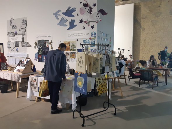 На 2-ому поверсі Мистецького арсеналу розмістилися стенди з дизайнерськими листівками, сумками, футболками