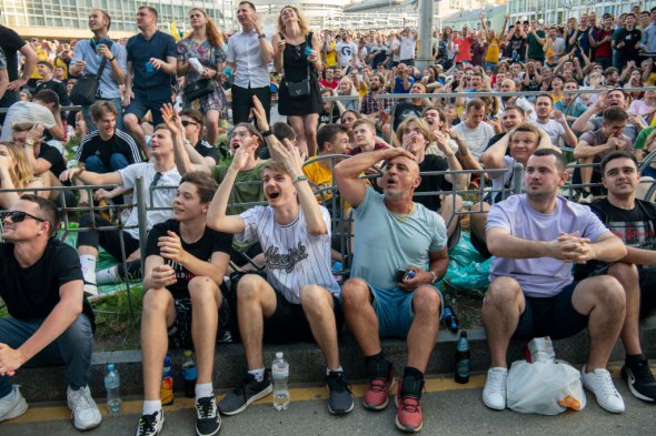 Українські вболівальники футболу сидять у фан-зоні в центрі Києва 21 червня 2021 року, спостерігаючи за матчем попереднього раунду групи С ЄВРО-2020 між Україною та Австрією, який проводиться у Бухаресті, Румунія.