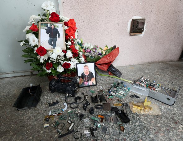 Деталі розбитої камери і квіти на місці побиття оператора, який помер через кілька днів 