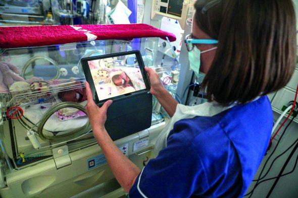 Медсестра знімає на відео новонародженого в лікарні британського міста Фрімлі у травні торік. Батькам заборонили навідувати малюків у відділенні через коронавірус. Персонал надсилав їм змімки і записи