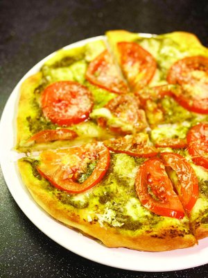 Піцу начиняють помідорами, ковбасою, зеленню та сиром. Випікають 15–20 хвилин за температури 180 градусів