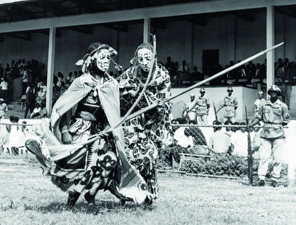 Жінки з племені Буєнзі виконують танець родючості на футбольному полі у столиці Бурунді Бужумбура 28 липня 1962-го. Вважали, що більше розмальоване білою глиною обличчя танцівниць і що ритмічніше вони рухаються, то краще вродять поля й сади. Виступили під час святкувань з нагоди проголошення незалежності Королівства Бурунді, яке було колонією Бельгії