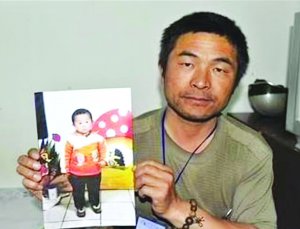Китаєць Гуо Гангтанг тримає фото вкраденого сина Ксінженя. Шукав його 24 роки. Прийомні батьки до 25-річчя не розповідали хлопцю, що купили його