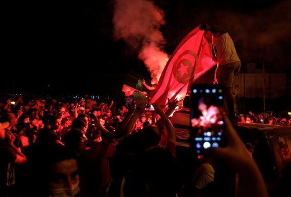 Сторонники президента Туниса Каиса Саида собираются на улицах во время празднования после того, как он освободил правительство и заморозил парламент.
