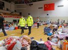Эвакуированные из особого района Линь-ган отдыхают на спортивном стадионе колледжа в Шанхае, когда тайфун Ин-фа обрушивается на прибрежные районы Китая.
