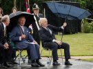 Британский принц Чарльз наблюдает за тем, как премьер-министр Борис Джонсон открывает свой зонт в Национальном мемориальном дендрарии в Стаффордшире, Великобритания