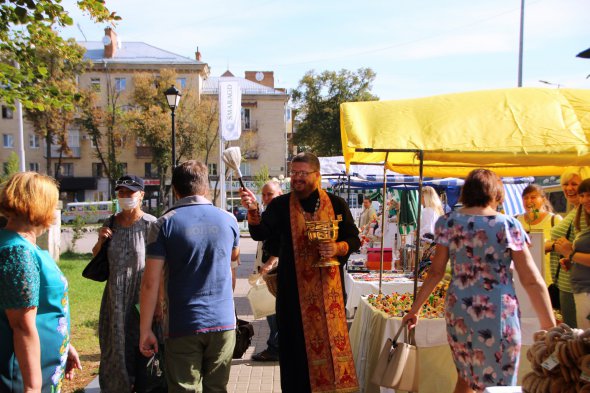 Священник освящает ярмарка меда в начале дня
