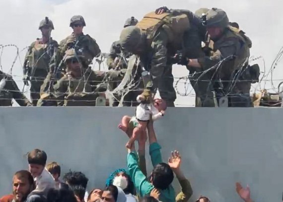 Младенец передается американской армии через стену по периметру аэропорта для его эвакуации в Кабуле, 19 августа 2021 года