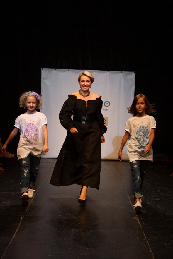 Журналистка и эксперт по деловому и бытовому этикету Татьяна Мокриди в черном платье проходится подиумом вместе с дочерьми