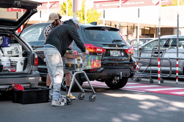 Люди вантажать покупки у багажник на парковці супермаркету New World у Веллінгтоні, Нова Зеландія. Торік у березні у країні оголосили карантин на чотири тижні. Супермаркетам і аптекам дозволили працювати, але впускали по одному покупцю. Можна було придбати обмежену кількість товарів