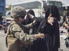 Морський піхотинець США перевіряє жінку в міжнародному аеропорту Хаміда Карзая, Кабул