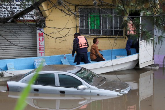 Спасательные команды эвакуируют жителей из их домов на лодке по затопленным улицам после проливного дождя, в результате которого погибли и пострадали люди, а автомобили и инфраструктура были повреждены, в Тула-де-Альенде, на окраине Мехико, Мексика