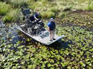 Мужчины на надувной лодке ищут аллигатора, который, как считается, убил человека после урагана Ида в Слайделле, штат Луизиана