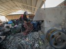 Иракский мужчина разрезает собранный из мусора пластик для переработки в Наджафе, Ирак