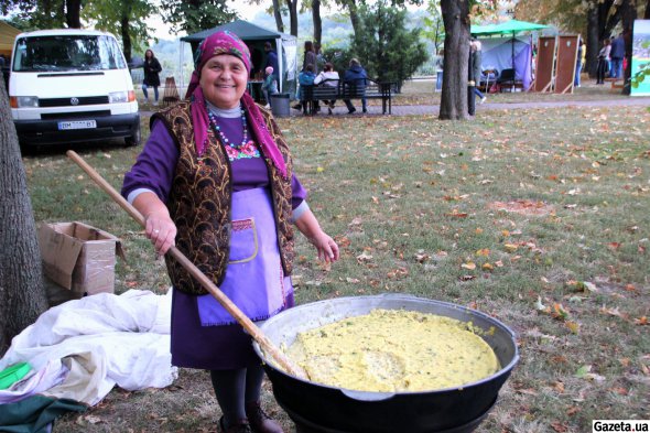Екатерина Пищаленко варит казацкую кашу в турецкьом котле во время фестиваля "Полтавская галушка"