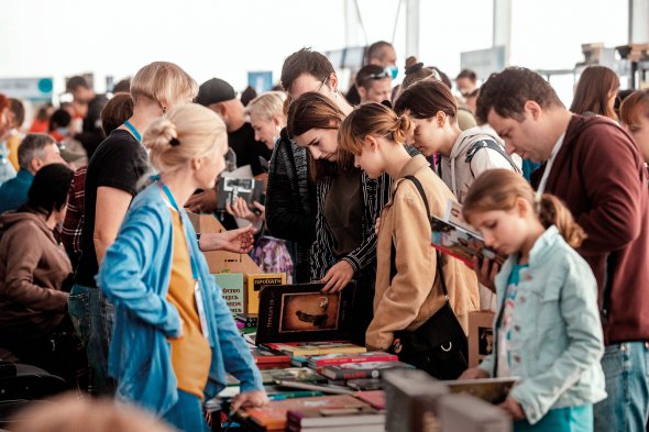 Відвідувачі IV Міжнародного книжкового фестивалю  Book Space у Дніпрі гортають новодруки на стенді видавництва ”Видавництво”