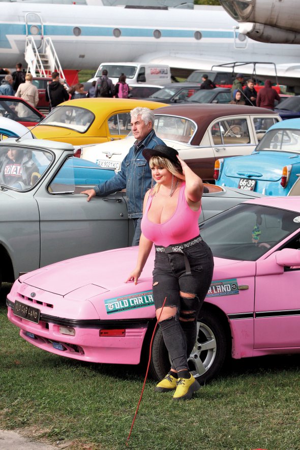 Модель 31-річна Міла Кузнєцова із 13-м розміром грудей позує біля єдиного в Україні рожевого Ford Probe. Отримала титул ”Найбільші жіночі натуральні груди” і ввійшла в Книгу рекордів України
