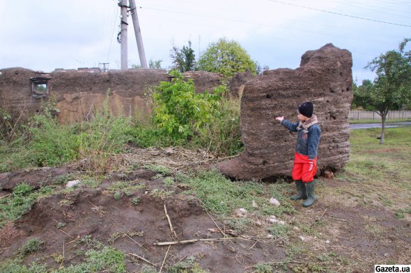 Михаил Темник показывает развалившуюся хату построенную на месте сарая Юрия Ткаленко. На этом участке нацисты сожгли более всего селян