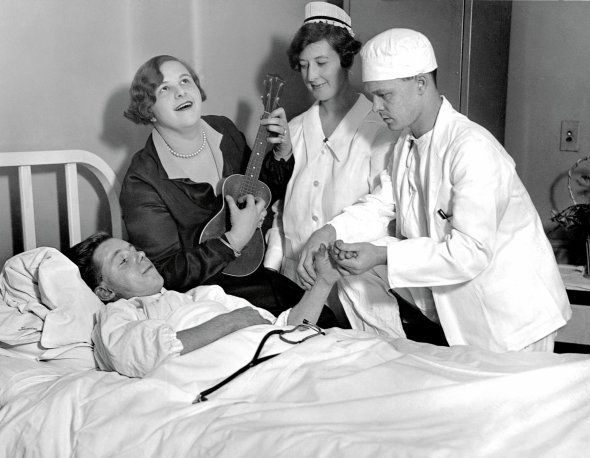 Артистка 19-річна Кейт Сміт співає і грає на гавайській гітарі перед хворим, якому починають робити операцію в нью-йоркській лікарні 7 жовтня 1926-го. Так відволікала увагу пацієнтів, яким був протипоказаний наркоз і давали лише знеболювальне. Люди менше боялися й переживали, а згодом швидше одужували. Кейт нагородили медаллю ”Легіон доблесті” і зробили почесним членом всесвітньої організації ”Червоний Хрест”