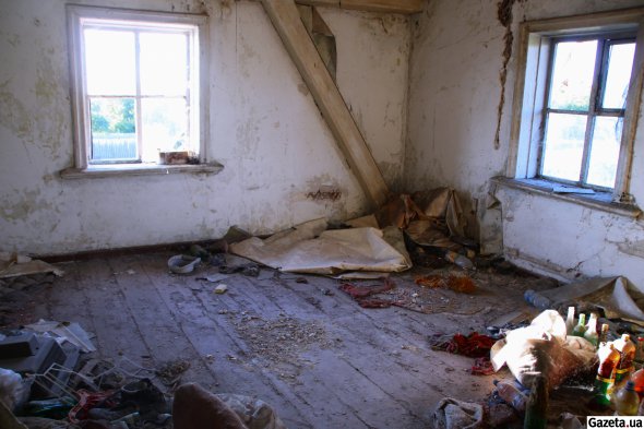На втором этаже "дома Малевича" заброшенные квартиры превратились в свалки. Со стен свисают обои, штукатурка обваливается, под дыры в крыше, из которого течет в дождь, подставлены старые ведра