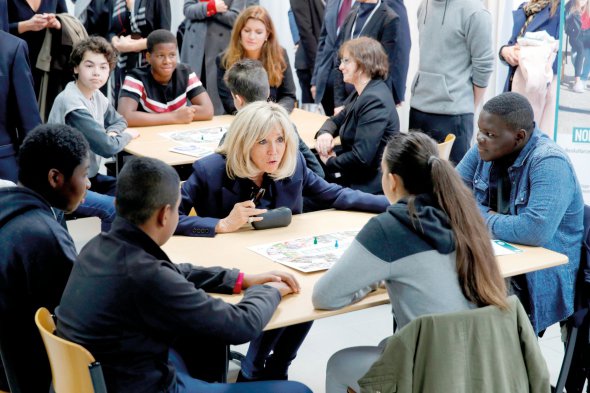 Перша леді Франції 68-річна Бріджит Макрон сидить на уроці у школі в передмісті Парижа. Зі старшокласниками обговорює, як запобігти цькуванню