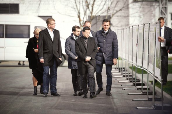 Охрана Владимира Зеленского придерживает металлические конструкции с информационными плакатами. От сильных порывов ветра они рискуют упасть. Президент находился в рабочей поездке в Черкасской области 20 октября. Кандидат в народные депутаты от партии ”Слуга народа” в округе №197 Виталий Войцеховский (на фото слева) встретил его в Каневе и сопровождал к Золотоноше