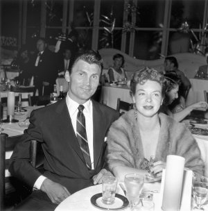 Актор Джек Паланс і його дружина Вірджинія Бейкер сидять за обіднім столом на вечірці у співачки Ґлорії Дехейвен у її будинку в Голлівуді, 14 вересня 1954 року