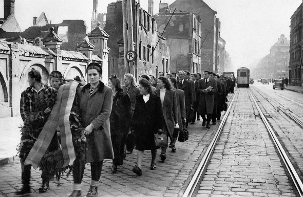 Люди несуть поминальні вінки в німецькому місті Мюнхен 14 березня 1948 року. Так вшановують жертв Голодомору в Україні. Це була перша масштабна акція з визнання геноциду українців. Її організували втікачі з Радянського Союзу під час Другої світової війни