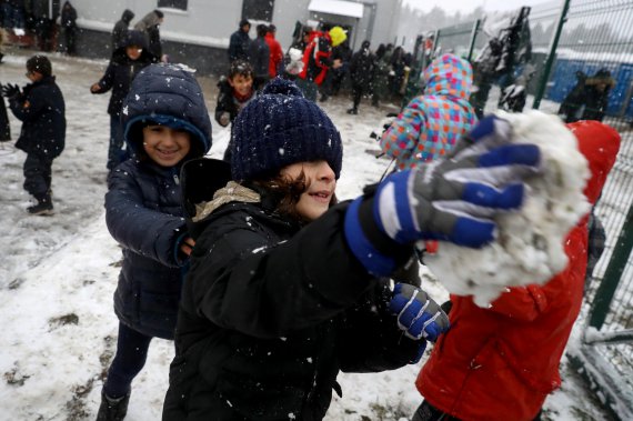 Дети мигрантов из Ближнего востока играются снегом, который увидели, наверно, впервые в жизни