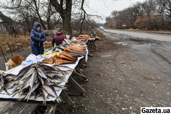 Женщины торгуют рыбой на обочине дороги в прифронтовой Карловке