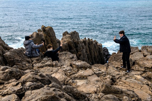 Японці сидять на скелях Тохінбо. У цьому місці часто стаються самогубства. Добровольці кілька разів на день патрулюють берег, щоб запобігти таким випадкам