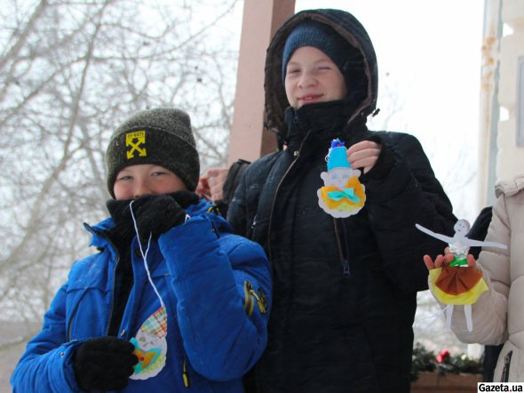 Пятиклассник Ярослав Кузьменко показывает елочное украшение в виде клоуна в голубой шляпе. Сделал ее на мастер-классе в музее Короленко