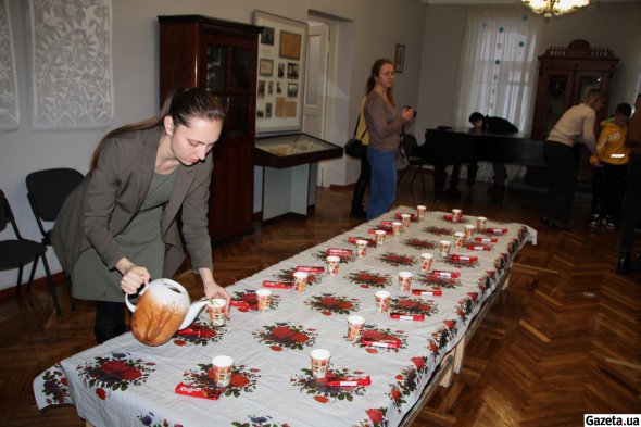 Наукова співробітниця музею Світлана Ємець розливає "короленківський" трав'яний чай для дітей, що приїхали на екскурсію
