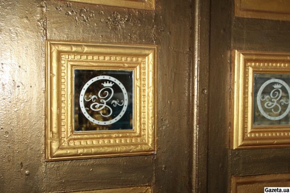 Входная дверь в подъезде украшена вензелями в виде букв G и S