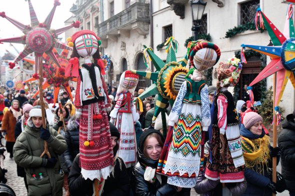 Учасники вертепу йдуть вулицями Львова під час фестивалю ”Спалах різдвяної звізди” 8 січня 2022 року. Несуть понад пів сотні великих різдвяних зірок. Їх виготовляють за традиційними техніками