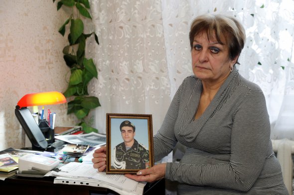 Надія Макаренко показує портрет сина Антона, який зник безвісти під час боїв на Донбасі у 2015 році. Вона досі не знає, що з ним трапилося