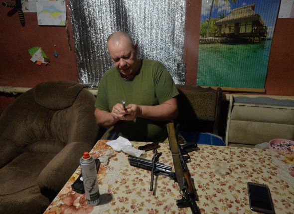 Украинский военный чистит оружие на позиции недалеко от оккупированной россиянами Горловки на Донбассе