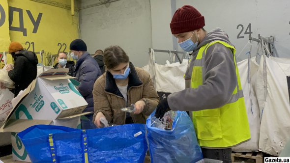 На фото адміністратор станції Остап Бутвинник допомагає відвідувачів відсортовувати сміття для спалювання