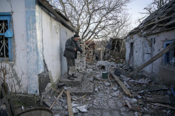 63-летний местный житель Валерий показывает здание, которое пострадало в результате обстрела в селе Тарамчук Донецкой области, Украина, 20 февраля