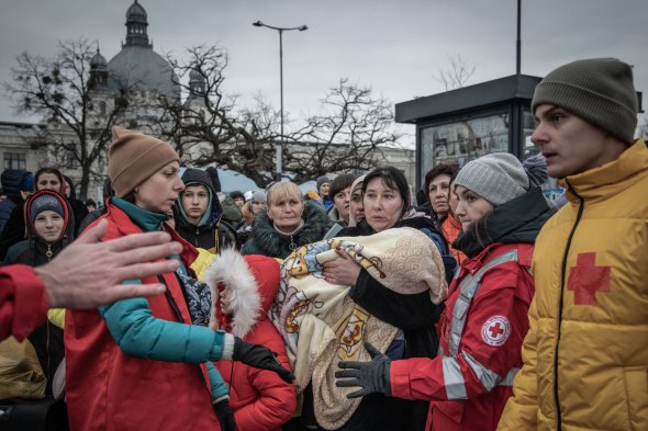 Працівники Червоного Хреста допомагають людям на вокзалі Львова 