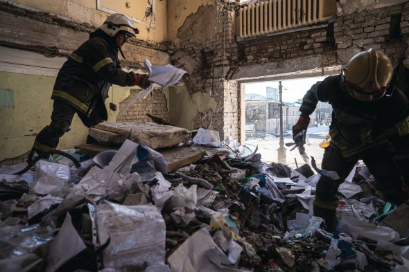 Рятувальники розчищають завали в будівлі облдержадміністрації в центрі Харкова, 19 березня 2022 року. Російська ракета влучила 1 березня в шестиповерхову споруду. Третина обвалилася. Загинули 10 людей, понад 20 — поранені