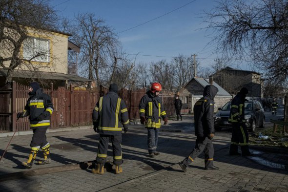 Пожарные на складе горючего, в который попала российская ракета, во Львове, в воскресенье 