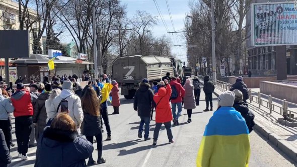 Демонстранты скандируют «Идите домой!», пока российские военные едут в Херсоне, 20 марта 