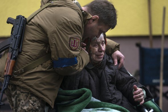 Солдат обіймає 82-річну жінку після її евакуації з Ірпеня, 30 березня 
