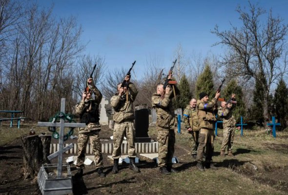 Члены территориальной обороны посещают могилу мужчины, убитого русскими солдатами