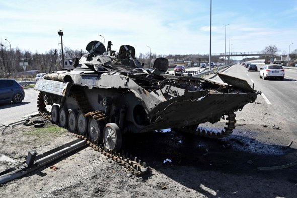 Автомобілі об’їжджають розбитий російський танк на трасі на Київщині. Більшість окупантів тікали від контратак військових Збройних сил України, залишали техніку. Зараз у напрямку столиці поступово відновлюють нормальний рух транспорту, відкривають мости