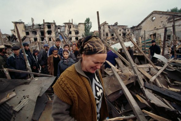 Чеченцы собираются после того, как за день до этого российский ракетный удар был нанесен по рынку в Грозном, 1999 год. Как и в Украине, убийства мирных жителей и нанесение ударов по гражданским районам - обычная тактика России во время Второй чеченской войны 