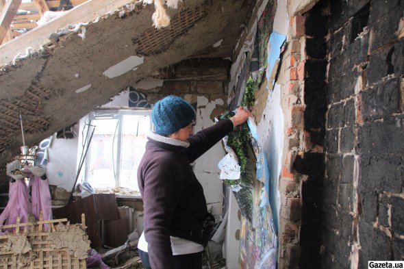 Жителька Охтирки Наталія Івахненко показує фотообої, які вони з чоловіком наклеїли 20 лютого у власному будинку, за два тижні до того як їх єдине житло зруйнувала російська авіабомба