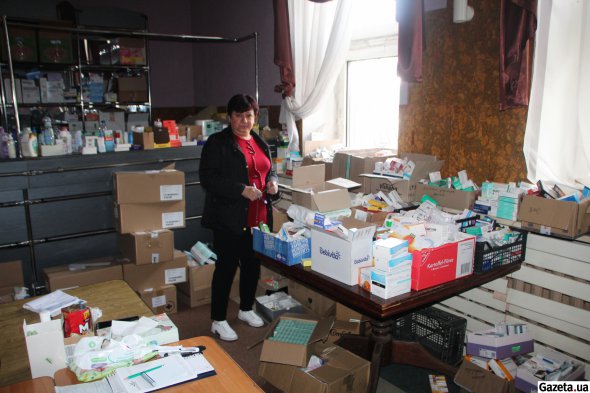 Провизор в штабе гуманитанской помощи берет на себя лекарства, которые бесплатно предоставляют людям по необходимостим