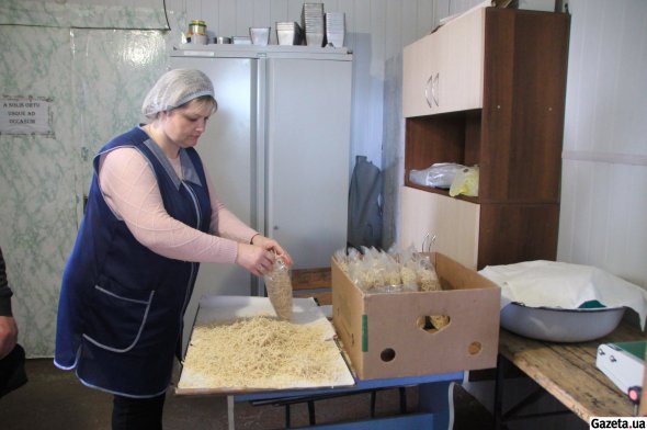 Волонтер Алена Романова упаковывает макаронные изделия